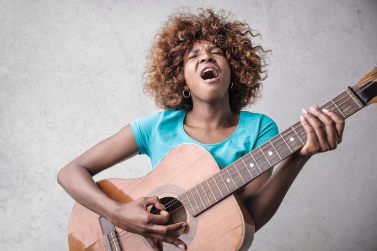 woman playing acoustic guitar while singing